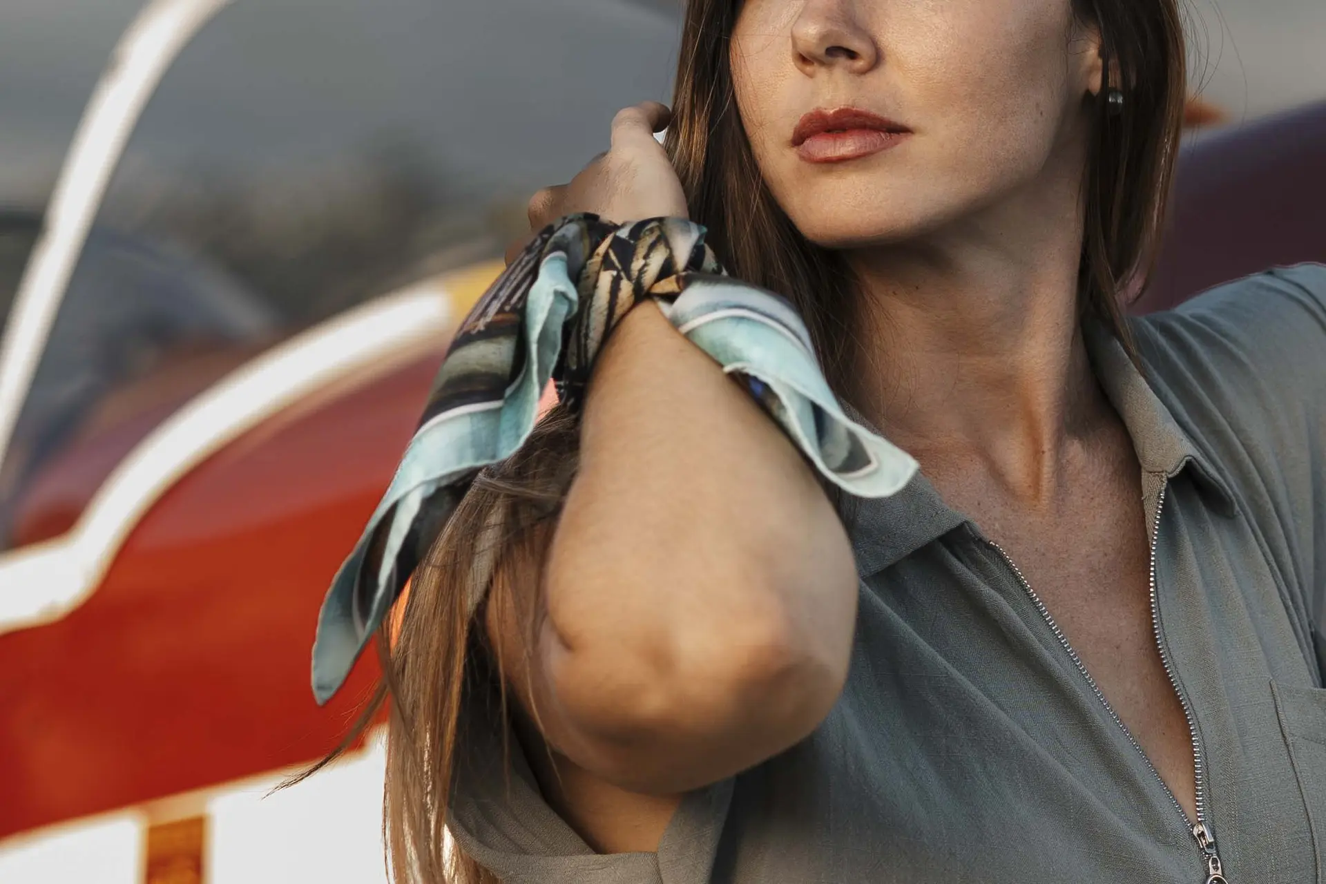 Gros plan sur un carré de soie Maison Devienne noué au poignet d’une femme, illustrant l’élégance, la légèreté et la qualité artisanale du foulard de luxe.