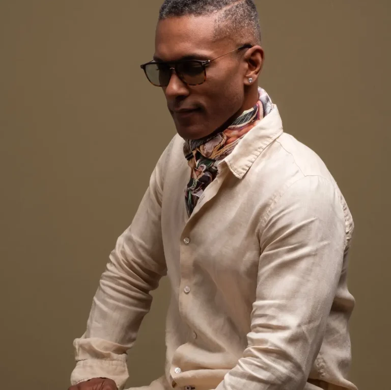 Homme portant un carré de soie Maison Devienne noué autour du cou, symbole d’élégance intemporelle et de savoir-faire français inspiré par la Polynésie.