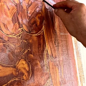 Main de Louis Devienne peignant à Tahiti les motifs qui inspirent les carrés de soie Maison Devienne, symbole d’un savoir-faire artistique et d’une création authentique.