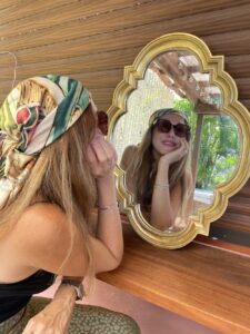 Luxury silk scarf worn as personal expression in front of a mirror